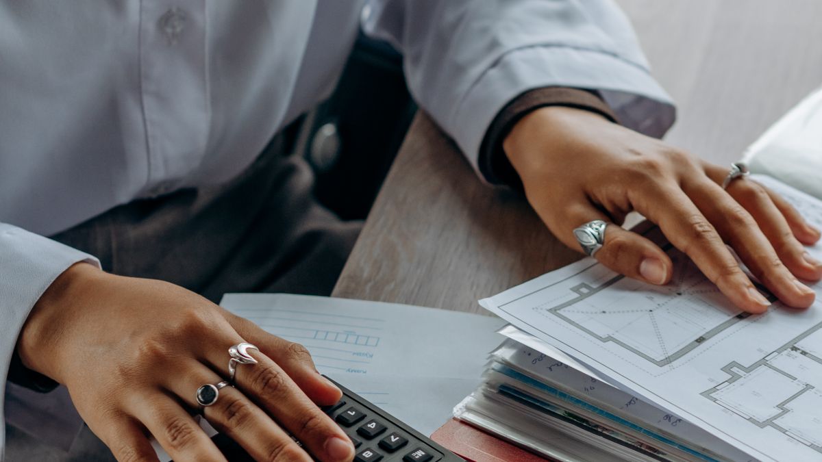 Une comptable vérifie des documents à la calculatrice