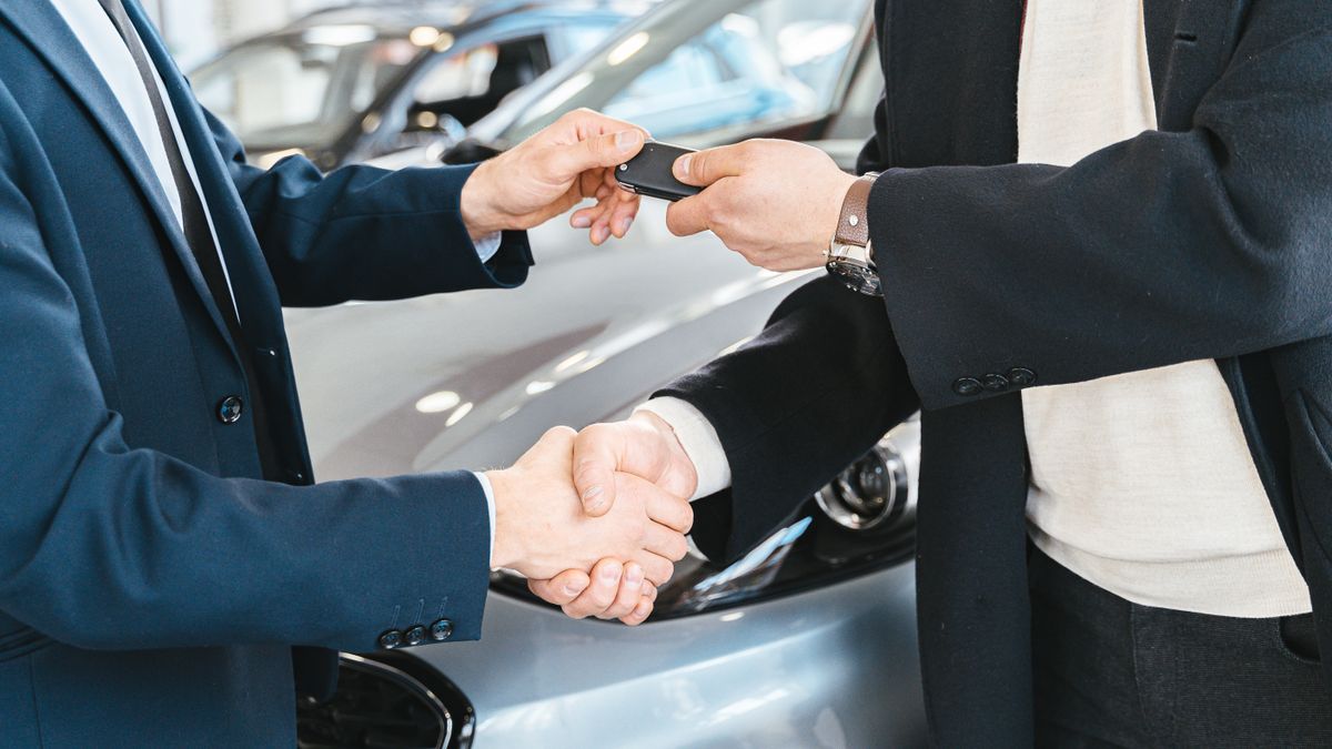 Poignée de main et remise des clés lors de la vente d'une voiture